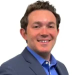 Professional headshot of Greg Praver of Atacama Resources International in blue suit against white background